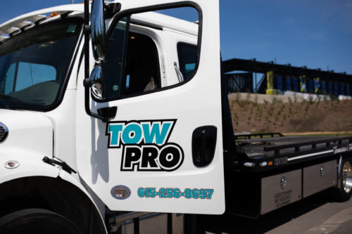 Tow Pro truck with door open sitting on road