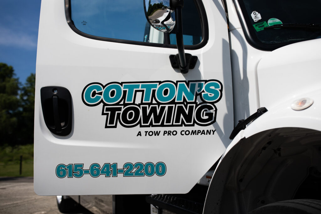 Upclose image of the door of a Cotton's Towing truck.